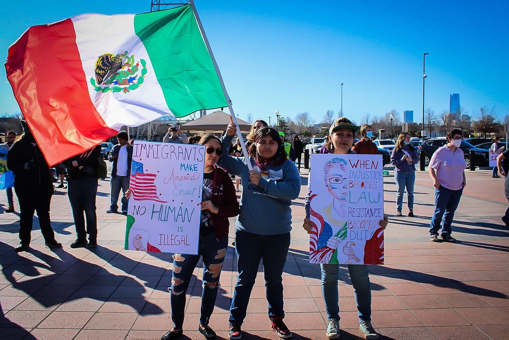 a group of people holding up signs at an event with Organizing Okies
